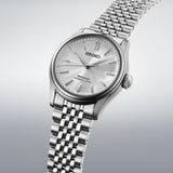 Seiko Presage HCC001J1 wristwatch with a stainless steel band and white dial, showcasing elegant design and classic style.